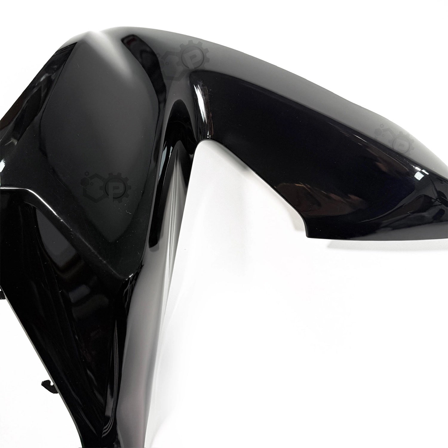 Close-up of a glossy black motorcycle part on a white background