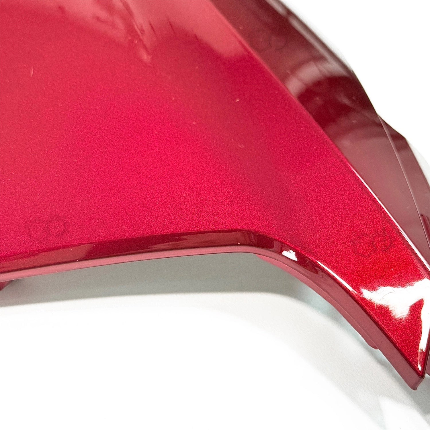 Close-up of a red car fender on a white background