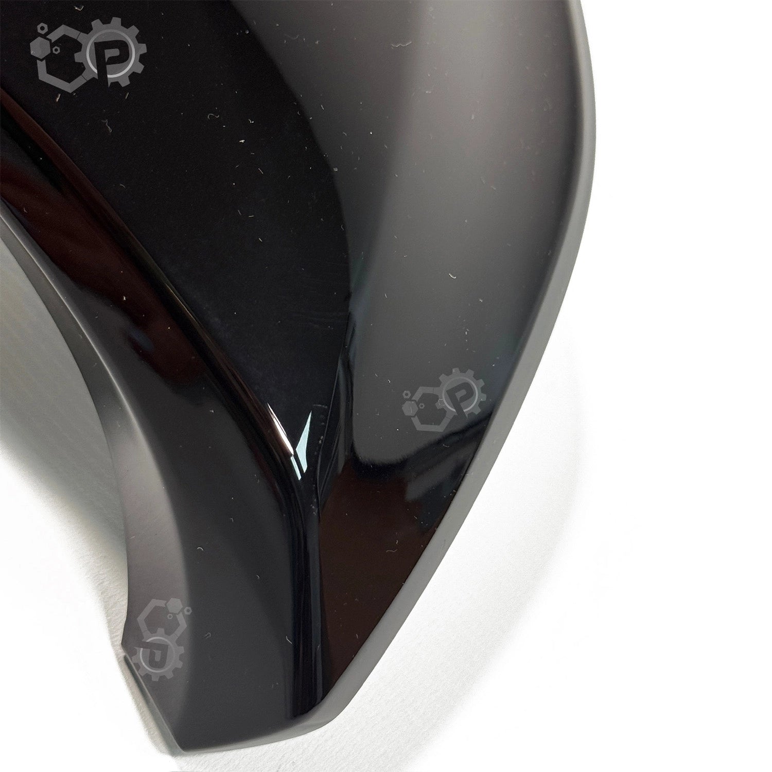 Close-up of a glossy black object with a brand logo on a white background