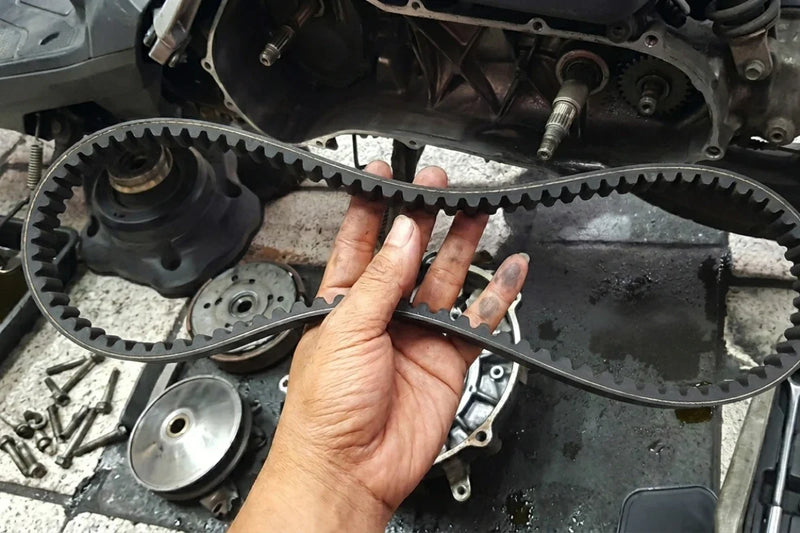 Close up of a drive new drive belt held by a mechanic in a workshop.