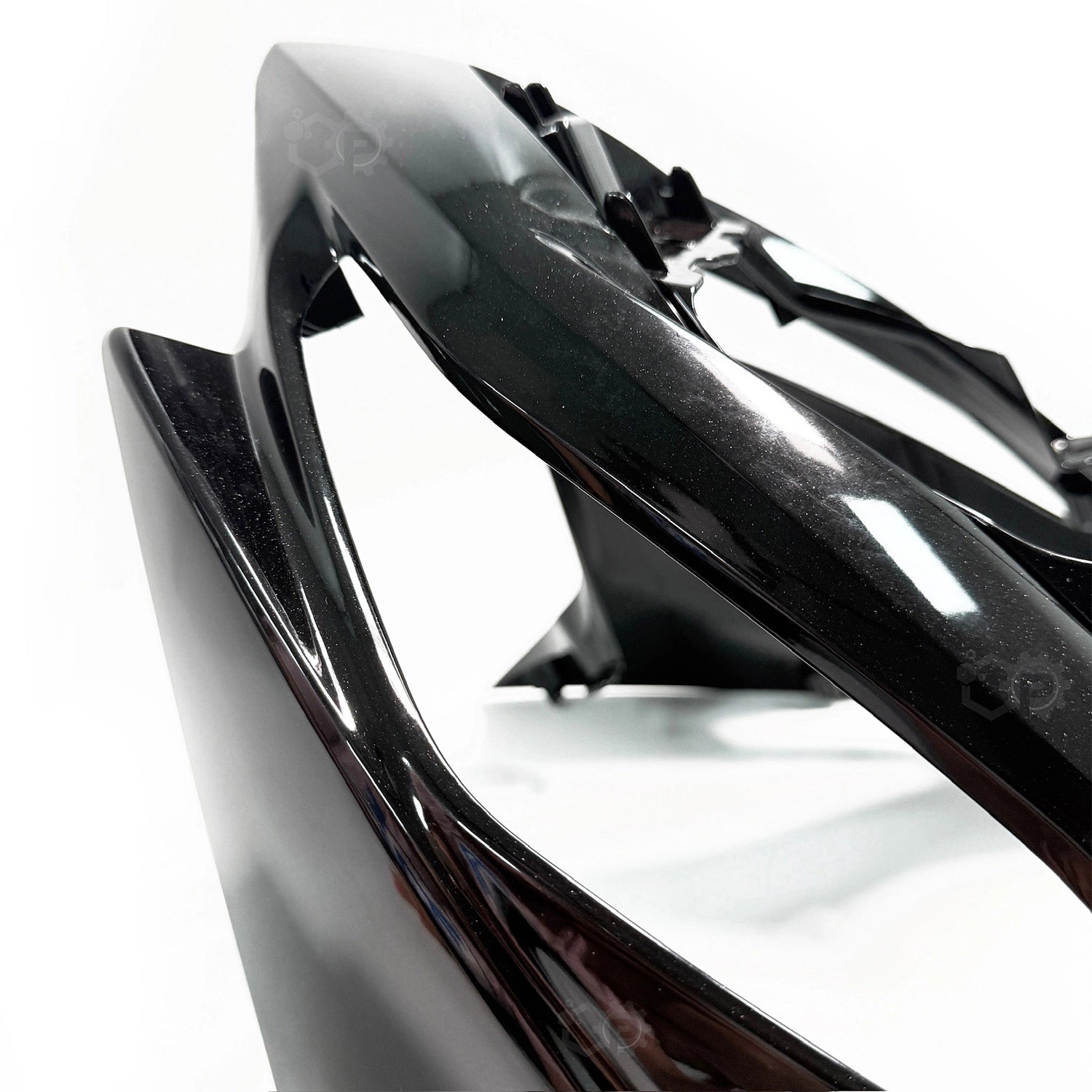 Close-up of a motorcycle headlight with a glossy finish on a white background